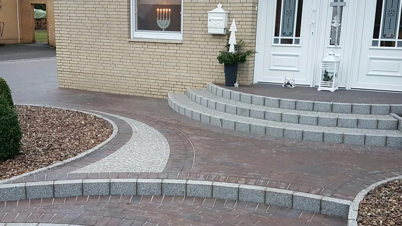 Auffahrt mit Treppe, Randeinfassung und frisch angelegten Beeten