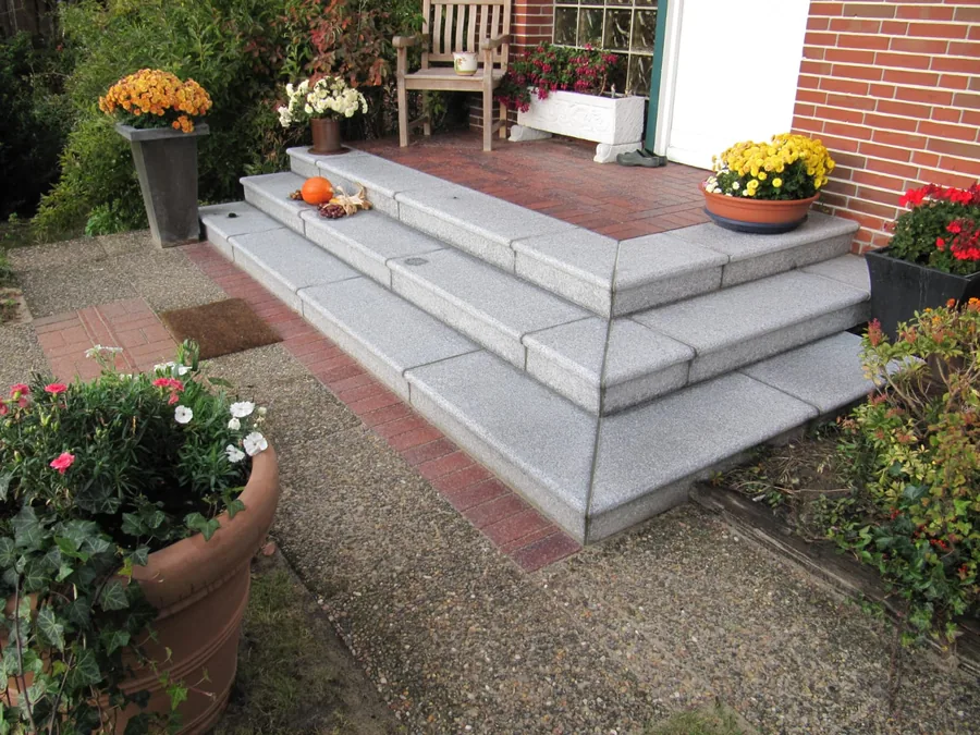 Granitstufen mit rotem Klinkerpodest und Blumenschmuck
