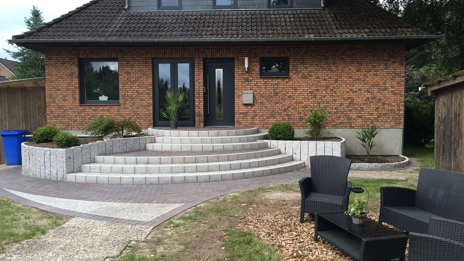 Bungalow mit gepflasterter Terrasse, Sitzplatz und angrenzendem Rasen