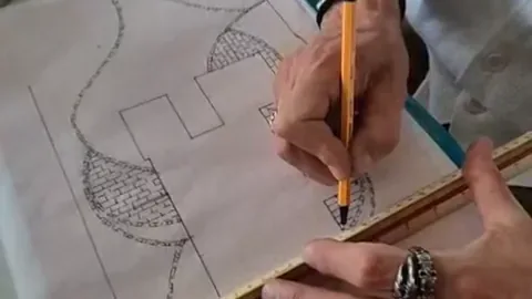 Ein Gartenplan wird mit Bleistift und Lineal von Hand gezeichnet